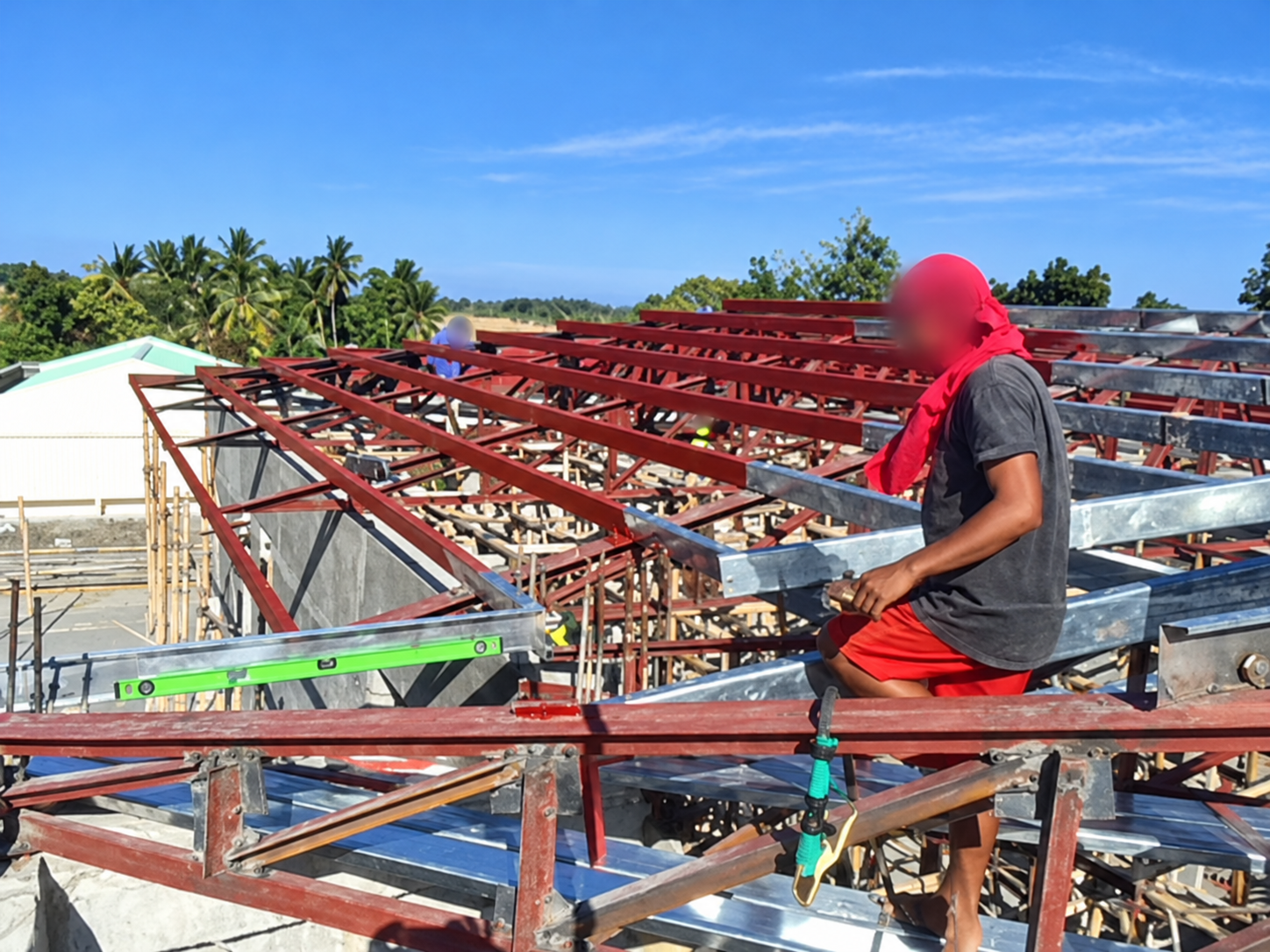 Worker assembling the church roof, face blurred